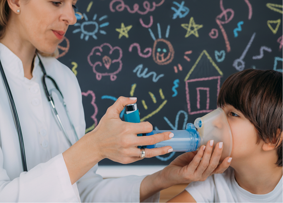 Niño utilizando un inhalador con ayuda de profesional médico